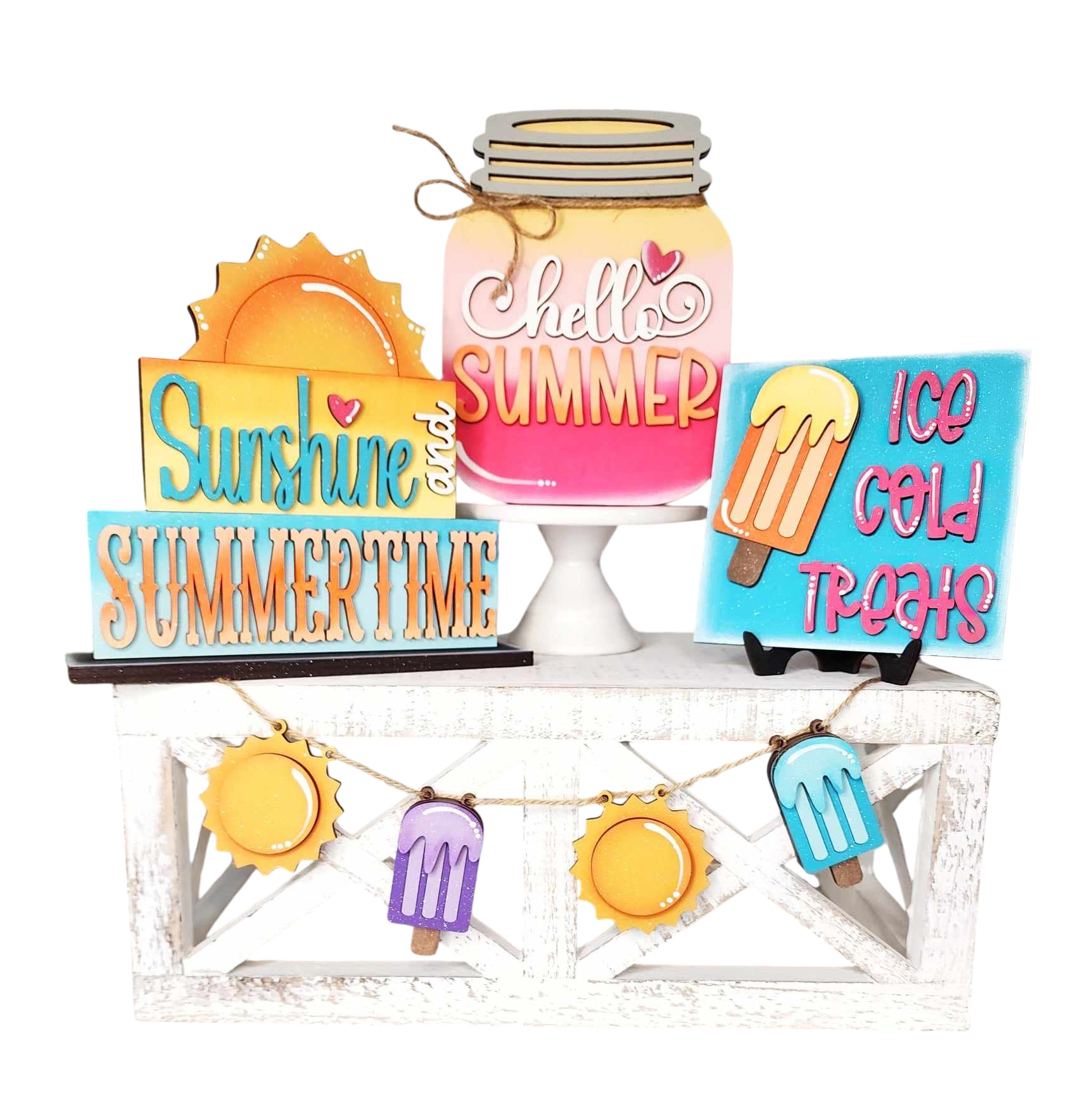 Create a vibrant summer display with The Rustic Rhode’s DIY Standing Summer Tiered Tray Kit, featuring word block signs—“Sunshine and Summertime,” “Hello Summer,” “Ice Cold Treats”—and sun/popsicle accents on a white stand.