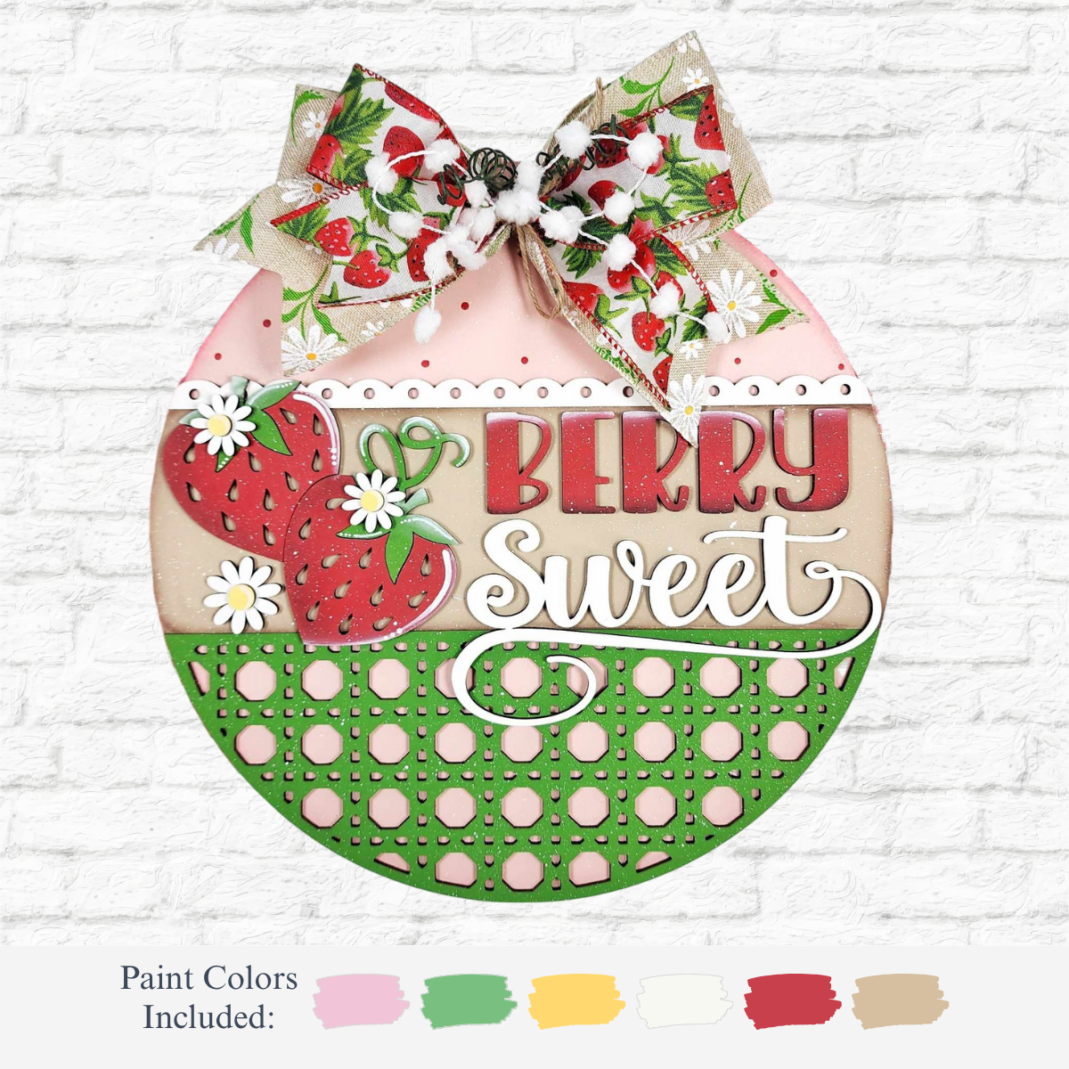 The Rustic Rhode’s DIY Berry Sweet Door Hanger features strawberries, daisies, a strawberry-patterned bow, and “Berry Sweet” text. Painted in pink, red, green, and cream. Paint color options available below.