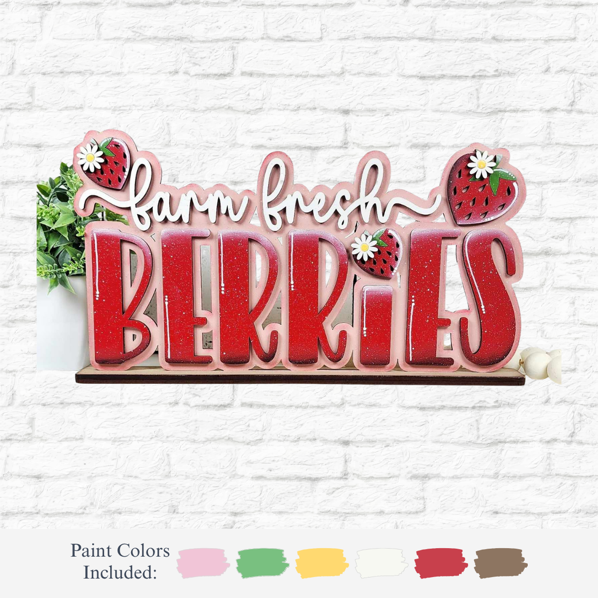 The Rustic Rhode’s DIY Berry Sweet Word Block craft kit features farm fresh BERRIES with strawberry and daisy accents, displayed on a white brick wall. Includes pink, green, yellow, red, and white paint colors.