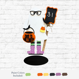 The Rustic Rhode’s DIY Halloween Countdown Ghost features glasses, holds a “31” chalkboard, a pumpkin bucket labeled “Days to Halloween,” and a candy bucket. It stands on a black oval base perfect for your festive décor.