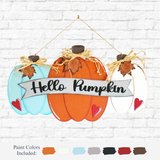 The Rustic Rhodes DIY Hello Pumpkin Door Hanger features three pumpkins—blue, orange, and white—with a Hello Pumpkin banner, leaves, raffia bows, red hearts, and paint colors shown below the sign.
