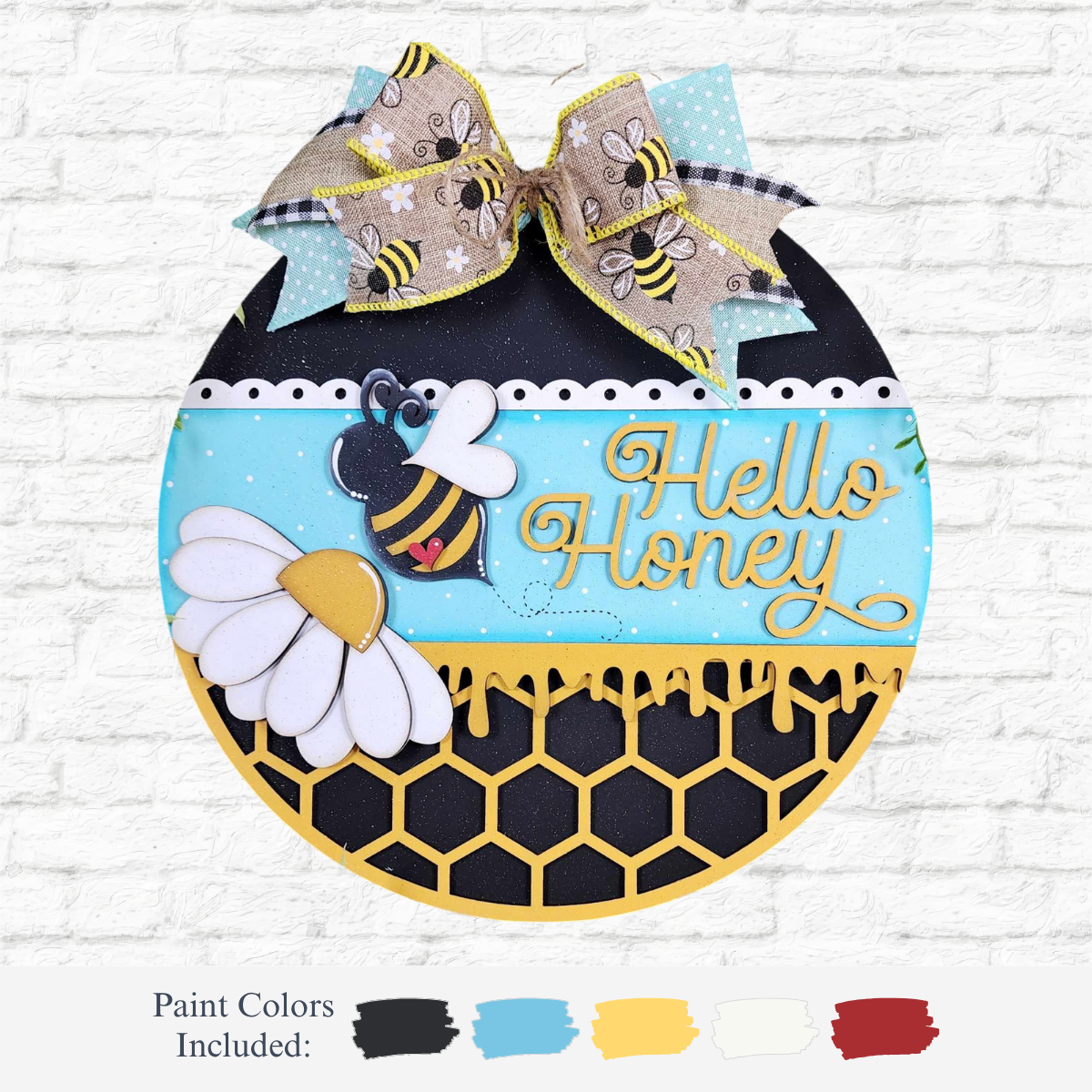 The Rustic Rhode DIY Honey Bee Door Hanger is a round, laser-cut wood sign with a bee, daisies, honeycomb pattern, and bee-print bow. It says Hello Honey in yellow script on blue—perfect for paint-your-own projects.
