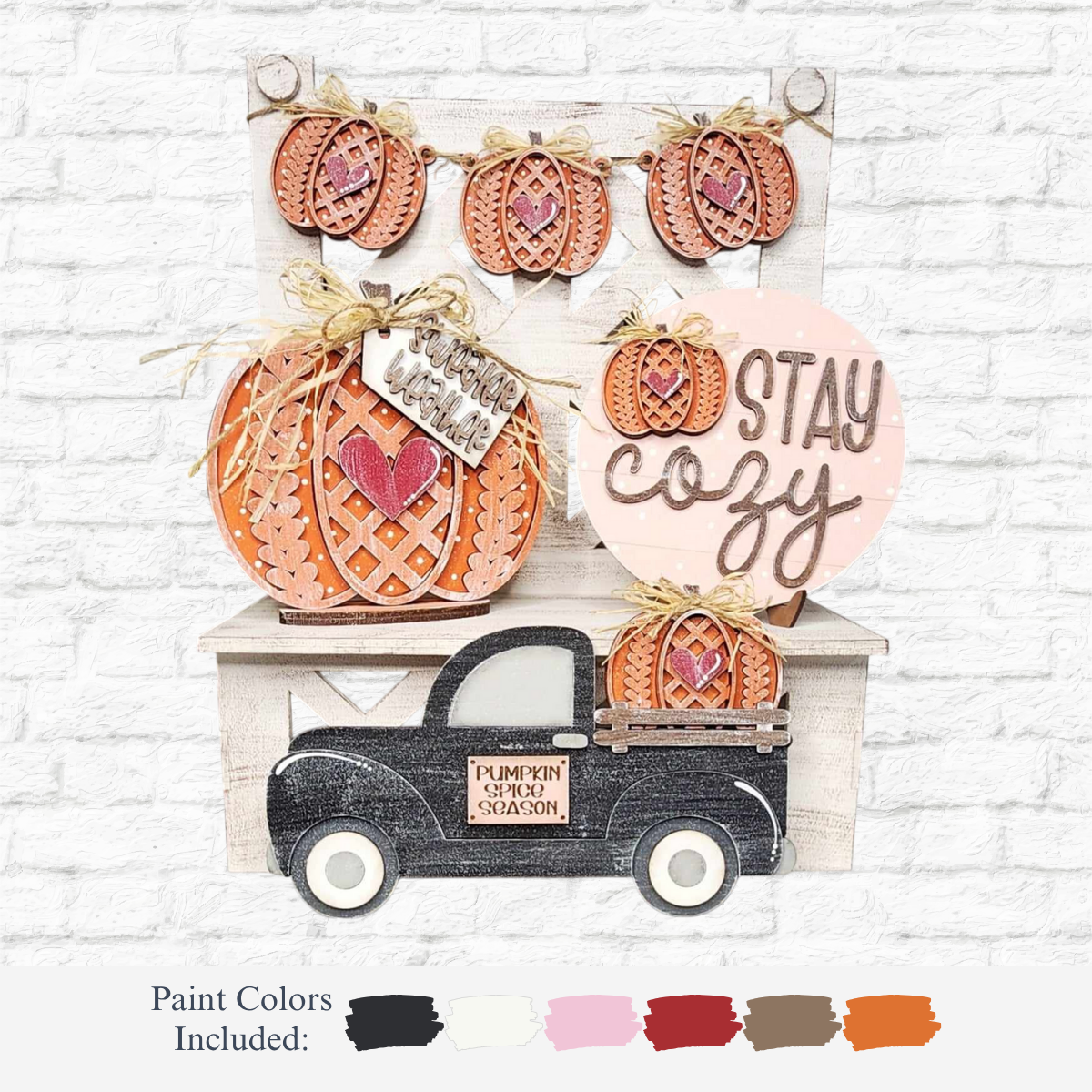 The Rustic Rhodes DIY Sweater Weather Tiered Tray Kit is a fall woodcraft set with pumpkins, a black truck, “Pumpkin Spice Season” and “Stay Cozy” signs. Includes paint in black, white, beige, pink, orange, brown, and red.