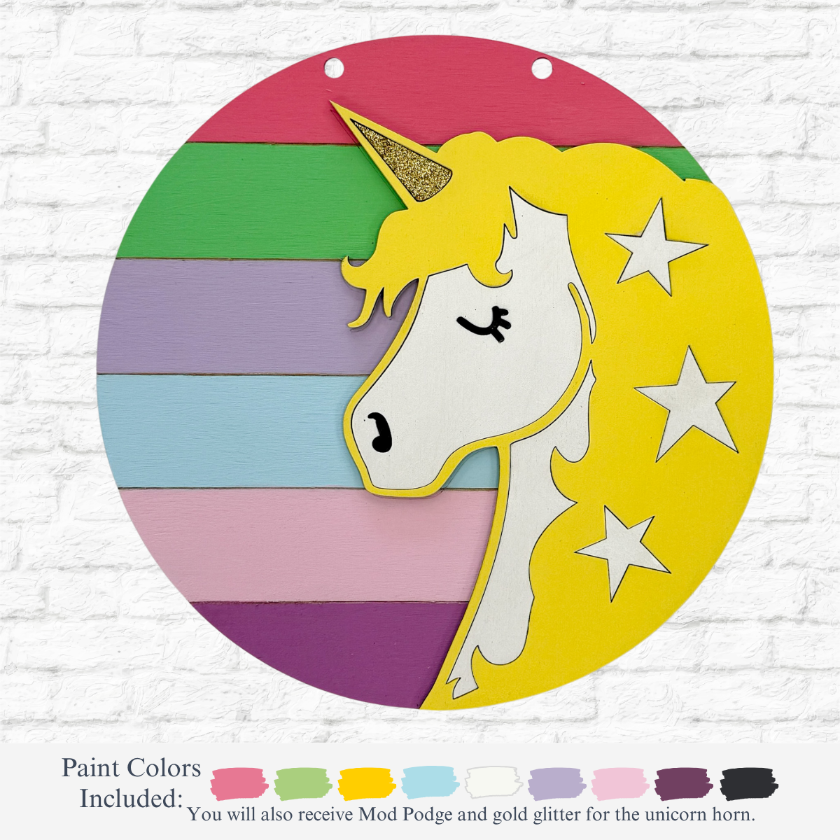 The Rustic Rhodes DIY Unicorn Kids Kit features a circular wooden sign with a painted unicorn head, gold horn, and stars on a yellow mane, set against pastel stripes. Includes multiple paint color options for a fun kids art activity.