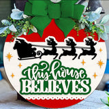 Celebrate the season with The Rustic Rhode's Set The Barre Fundraiser-October 25th: a festive DIY door hanger kit featuring a green bow, greenery, Santa's sleigh silhouette, and "This House Believes" for holiday cheer!.