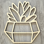 The Rustic Rhode’s M. Mello Suncatcher Workshop- 10/7 features a geometric plant pot wooden cutout with stylized leaves and two top holes for hanging—perfect for DIY suncatchers or creative workshop projects.