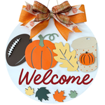 A round fall-themed door hanger by The Rustic Rhode for the Warwick Softball Fundraiser (10/2/25), featuring a pumpkin, football, colorful leaves, coffee cup, orange plaid bow, and "Welcome" in red script.