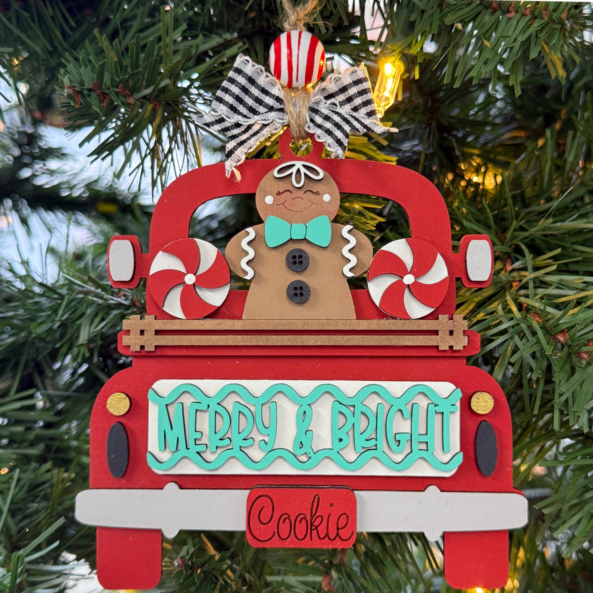 The Rustic Rhode's DIY Truck Ornament- Merry & Bright features a red truck-shaped ornament with a smiling gingerbread, peppermint candies, and a "Merry & Bright Cookie" sign—perfect for assembling or painting and hanging on your festive tree.