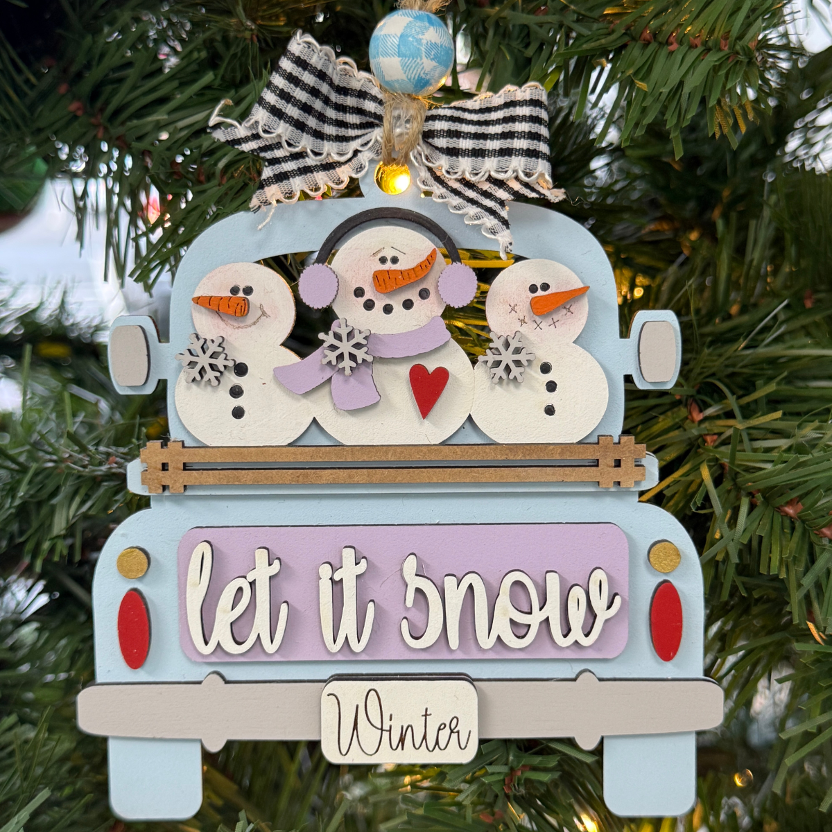 The Rustic Rhode DIY Truck Ornament- Let It Snow features a blue truck with three snowmen, festive signs, and a checked bow—ready to paint and assemble for your Christmas tree.