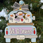 The Rustic Rhode DIY Truck Ornament- Let It Snow features a blue truck with three snowmen, festive signs, and a checked bow—ready to paint and assemble for your Christmas tree.