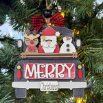 The Rustic Rhode DIY Truck Ornament- Santa's Friends kit features a black truck with "Merry Christmas," carrying a reindeer, Santa, and snowman. Includes unassembled pieces, red plaid bow topper, and green tree accents—just add paint!.