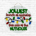 Cathy's Craft Night by The Rustic Rhode features a round door hanger with colorful Christmas lights and the words "Jolliest bunch of assholes this side of the nuthouse," displayed on a white brick wall. Event: Nov 13, 6:00pm.