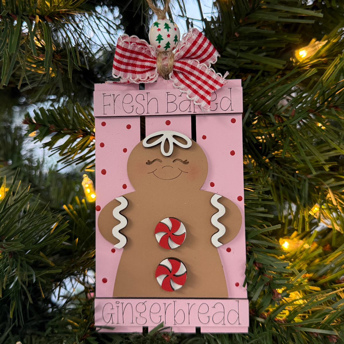 The Rustic Rhode DIY Fresh Baked Gingerbread Pallet Ornament features a gingerbread cookie design on a pink rectangle with red polka dots—perfect for ornament kits, unassembled pieces, or customizing with your own paint.