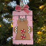 The Rustic Rhode DIY Fresh Baked Gingerbread Pallet Ornament features a gingerbread cookie design on a pink rectangle with red polka dots—perfect for ornament kits, unassembled pieces, or customizing with your own paint.