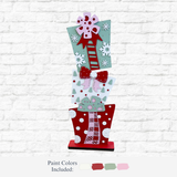 The Rustic Rhode DIY 32 Inch Stacked Presents features three painted wooden gift boxes with bows, polka dots, and snowflakes in red, white, and pale green—ideal for festive holiday decor or as oversized stacked presents.