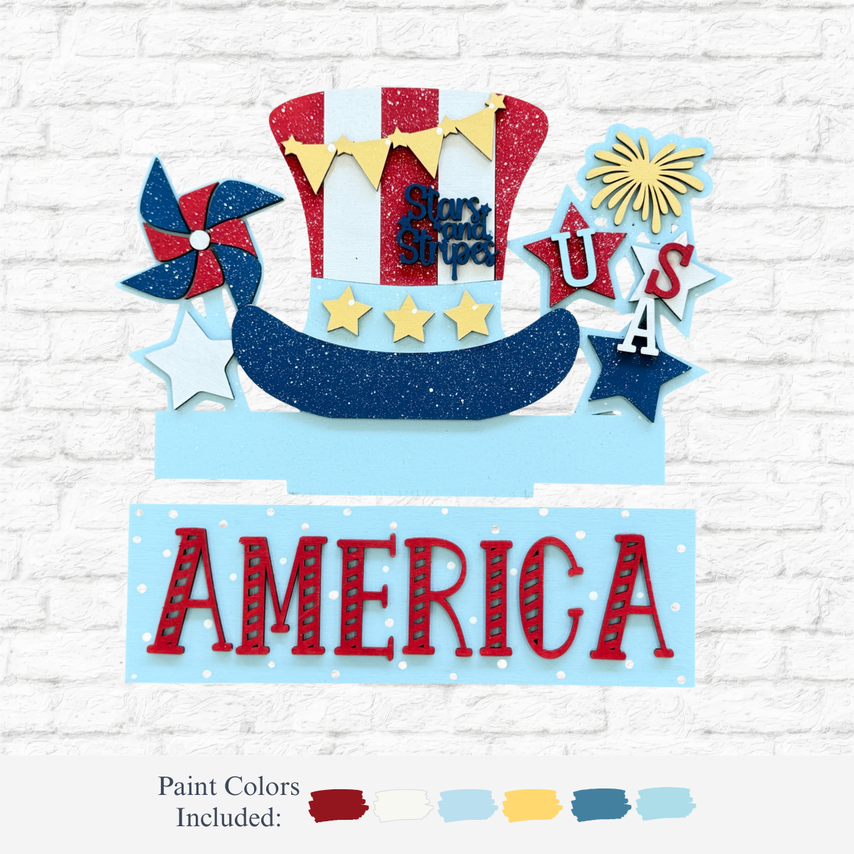 The Rustic Rhode’s DIY America 2 Piece Insert features a glittery Uncle Sam hat, stars, a pinwheel, and bold red AMERICA letters—ideal for your Interchangeable Window Frame or as a festive DIY Pumpkin Insert. Paint colors shown below on a white brick background.