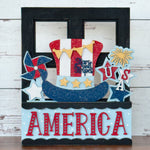 The Rustic Rhode DIY America 2 Piece Insert features a patriotic design with a sparkling Uncle Sam hat, stars, USA, and AMERICA in red, white, blue, and gold—ideal for interchangeable window frames or handmade craft kits.