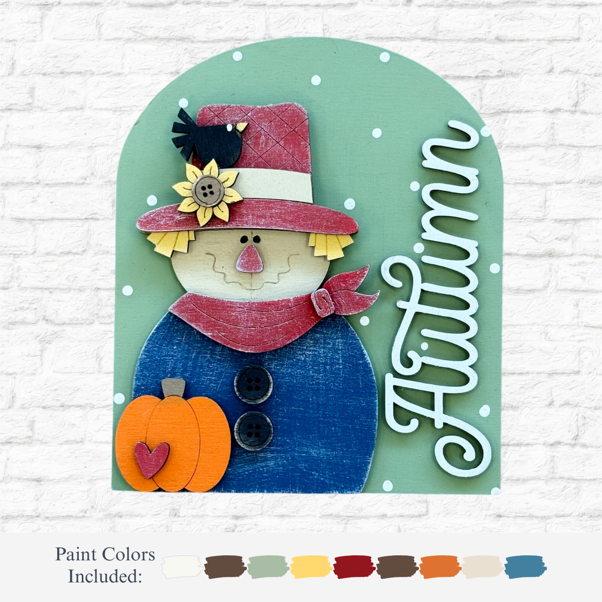 The Rustic Rhode’s DIY Autumn Scarecrow Arch Insert features a smiling scarecrow with a sunflower hat, blue coat, red scarf, and orange pumpkin on a green background with white dots and “Autumn” in script.
