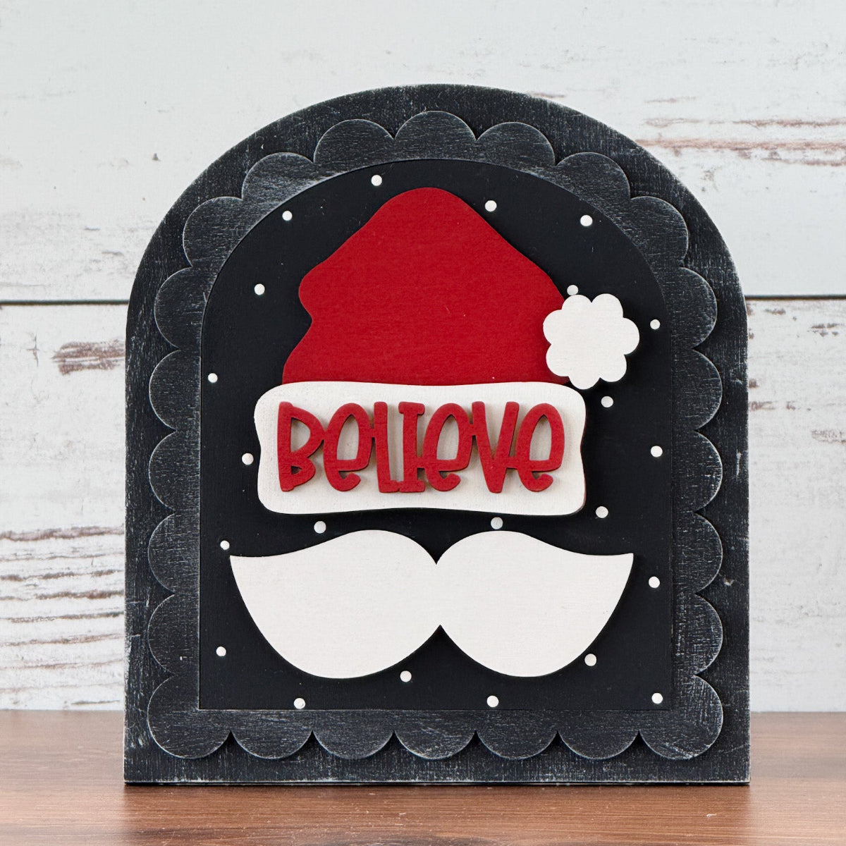 The Rustic Rhodes DIY Believe In Santa Arch Insert features “BELIEVE” in red, a Santa hat, white mustache, and polka dots on a Scalloped Arch—perfect seasonal décor for your home.