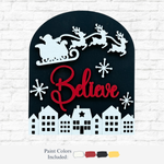 The Rustic Rhode’s DIY Believe In Santa Arch Insert features a white Santa sleigh and reindeer over red “Believe” script, with snowy houses below. Designed for Scalloped Arch Frames; paint colors included: white, black, red, yellow.