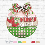 The Rustic Rhode’s DIY Berry Sweet Door Hanger features strawberries, daisies, a strawberry-patterned bow, and “Berry Sweet” text. Painted in pink, red, green, and cream. Paint color options available below.