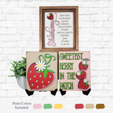 Three strawberry-themed signs from The Rustic Rhode DIY Berry Sweet Sign Trio are displayed against a white brick wall, accompanied by two paint pots, green leaves, and swatches of seven paint colors below.