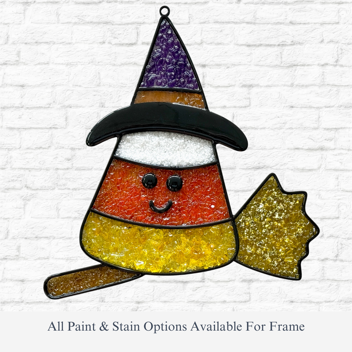 The Rustic Rhode DIY Candy Corn Witch Faux Suncatcher features a smiling candy corn witch with a black hat and yellow broom, shown on a white brick background. All paint & stain options available for the frame.