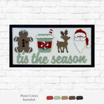 The Rustic Rhode’s DIY Christmas Tis The Season sign features a gingerbread person, festive cup, reindeer, and Santa above “’tis the season” in green—perfect holiday décor or a fun DIY project. Paint samples shown below.