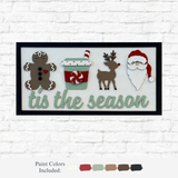 The Rustic Rhode’s DIY Christmas Tis The Season sign features a gingerbread person, festive cup, reindeer, and Santa above “’tis the season” in green—perfect holiday décor or a fun DIY project. Paint samples shown below.