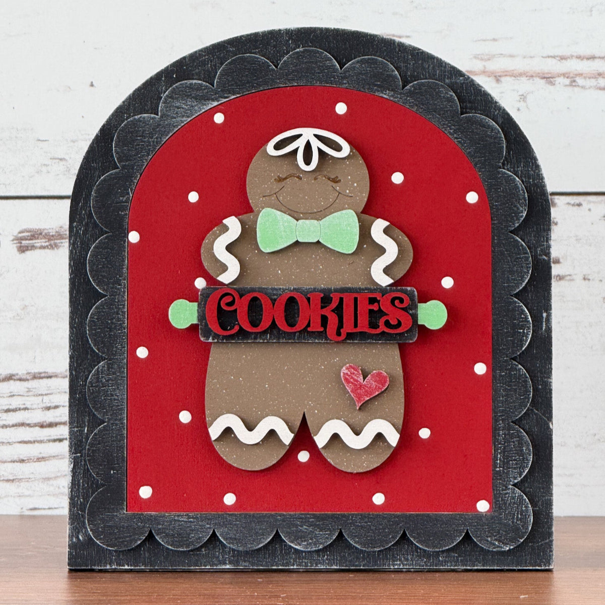 Decorative sign with a gingerbread man design on a red background, featuring the word 'COOKIES'.