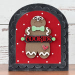 Decorative sign with a gingerbread man design on a red background, featuring the word 'COOKIES'.
