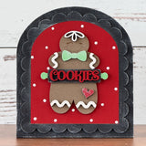 Decorative sign with a gingerbread man design on a red background, featuring the word 'COOKIES'.