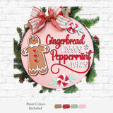 The Rustic Rhode DIY Gingerbread Door Hanger features a round pink holiday sign with a gingerbread, peppermint candies, “Gingerbread Kisses & Peppermint Wishes” text, topped with a red plaid bow and greenery. Paint colors shown below.