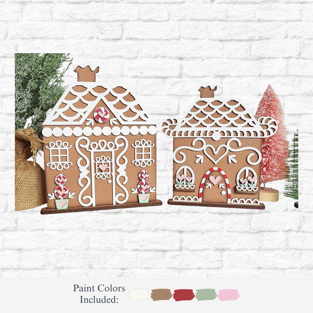 Two wooden gingerbread house decorations from The Rustic Rhode’s DIY Gingerbread Houses kit are painted with tan, red, green, and white and displayed in front of festive trees. Four paint colors are shown below the product image.