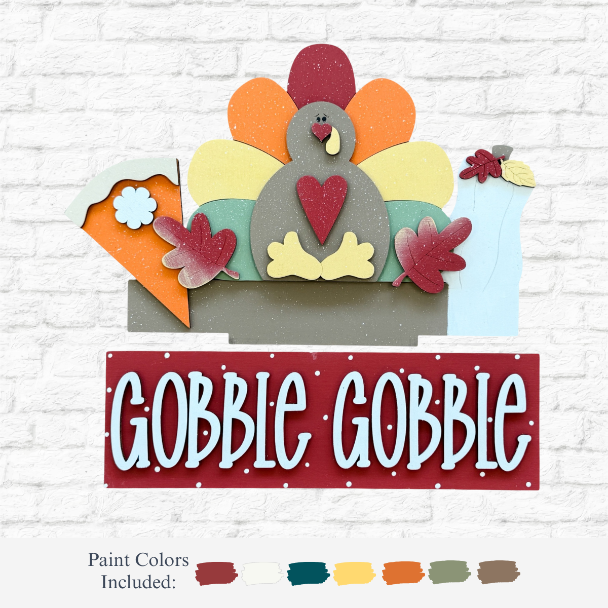 The Rustic Rhode’s DIY Gobble Gobble 2 Piece Insert features a colorful wooden turkey, pie, leaves, vase, and GOBBLE GOBBLE on a red panel—paint included. Perfect handmade Thanksgiving décor for your home!.