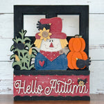 The Rustic Rhode DIY Hello Autumn 2 Piece Insert features a scarecrow with a red hat, sunflower, corn stalks, pumpkin, black crow, and Hello Autumn script—ideal for interchangeable window frames or handmade fall decor.