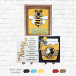 The Rustic Rhode DIY Honey Bee Sign Trio—three bee-themed decorative signs—are shown against a white brick wall. Paint Colors Included (black, brown, blue, yellow, white, and cream) swatches are displayed below.
