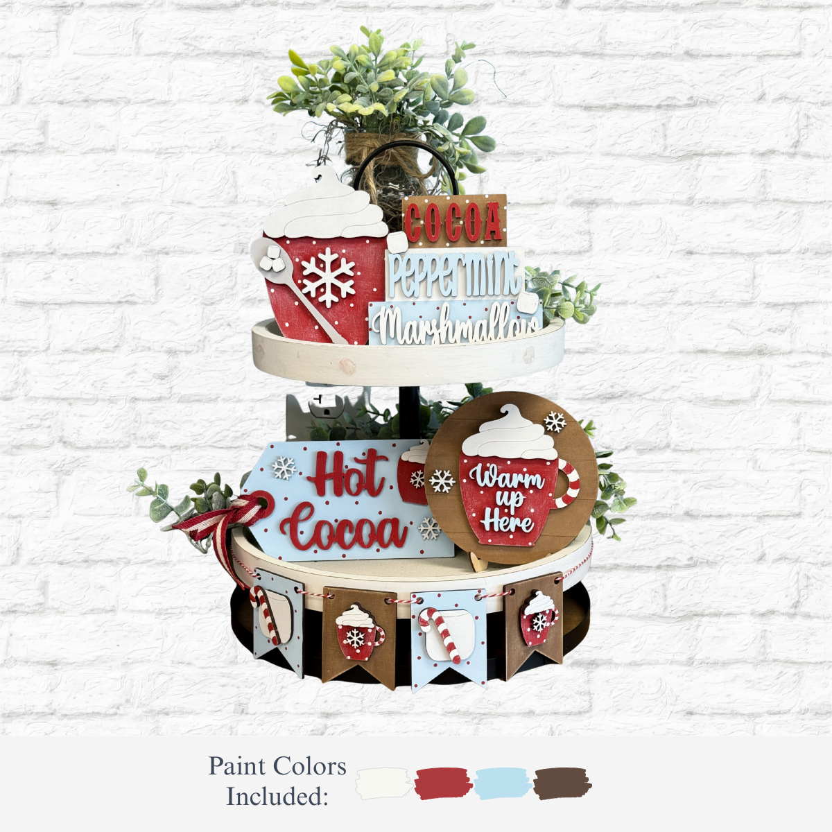 The Rustic Rhode’s DIY Hot Cocoa Tiered Tray Kit features Victorian-inspired decor with wooden cocoa signs, faux whipped cream mugs, snowflakes, greenery, a mini banner, and paint in cream, red, light blue, and brown—ideal for your next project.