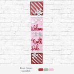 The Rustic Rhode's DIY North Pole Porch Leaner features “Welcome to the North Pole” text, Santa’s sleigh, and festive colors—perfect Christmas porch decor for your white brick wall.