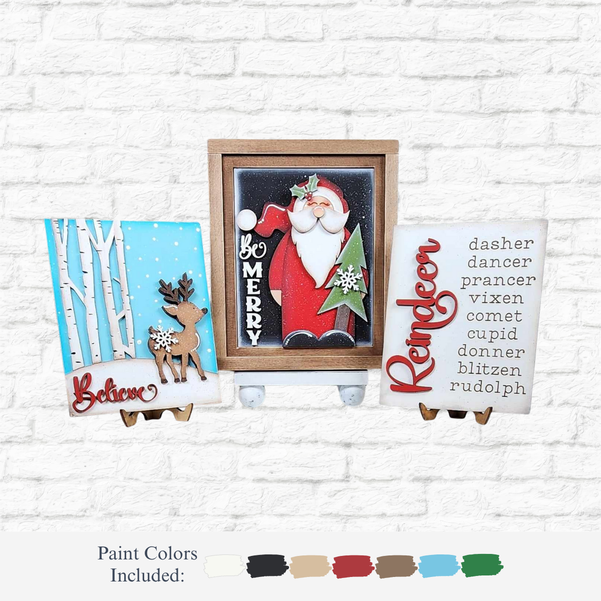 The Rustic Rhode DIY Oh Deer Sign Trio features Christmas-themed wooden crafts: a "Believe" reindeer, "Be Merry" Santa, and red-named reindeers. Perfect for festive DIY signs; paint colors shown on a white brick background.