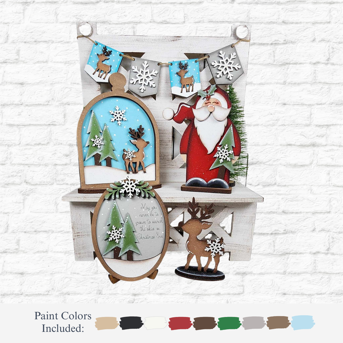 The Rustic Rhode's DIY Oh Deer Tiered Tray Kit features painted Santa, reindeer, snowflakes, trees, and a festive banner—perfect holiday décor for white shelves against a brick wall. Paint colors for the door hanger are shown below.