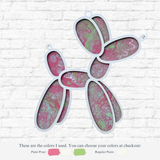 The Rustic Rhodes DIY Paint Pour- Balloon Dog wall art features swirling pink, green, and white paint in each segment, set against a white brick wall. Below are labeled pink and green crafting paint samples for home use.