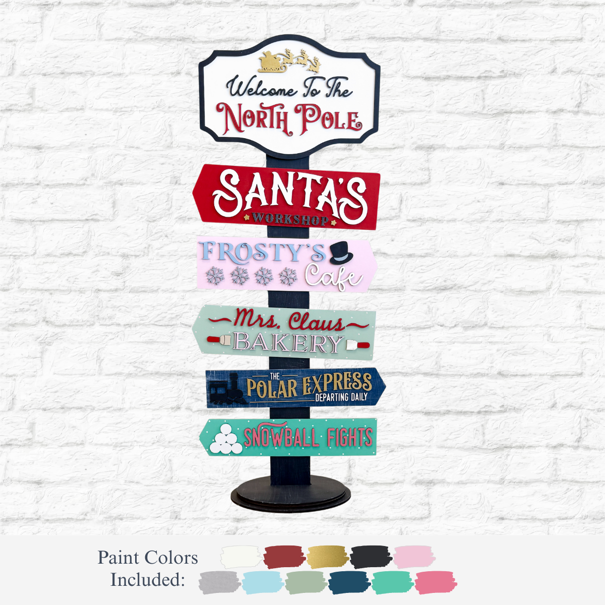 The Rustic Rhode DIY Santa's Workshop Directional Signpost features six festive arrows, including “Welcome to the North Pole” and “Santa’s Workshop”—a perfect holiday décor piece! Paint color swatches shown below.