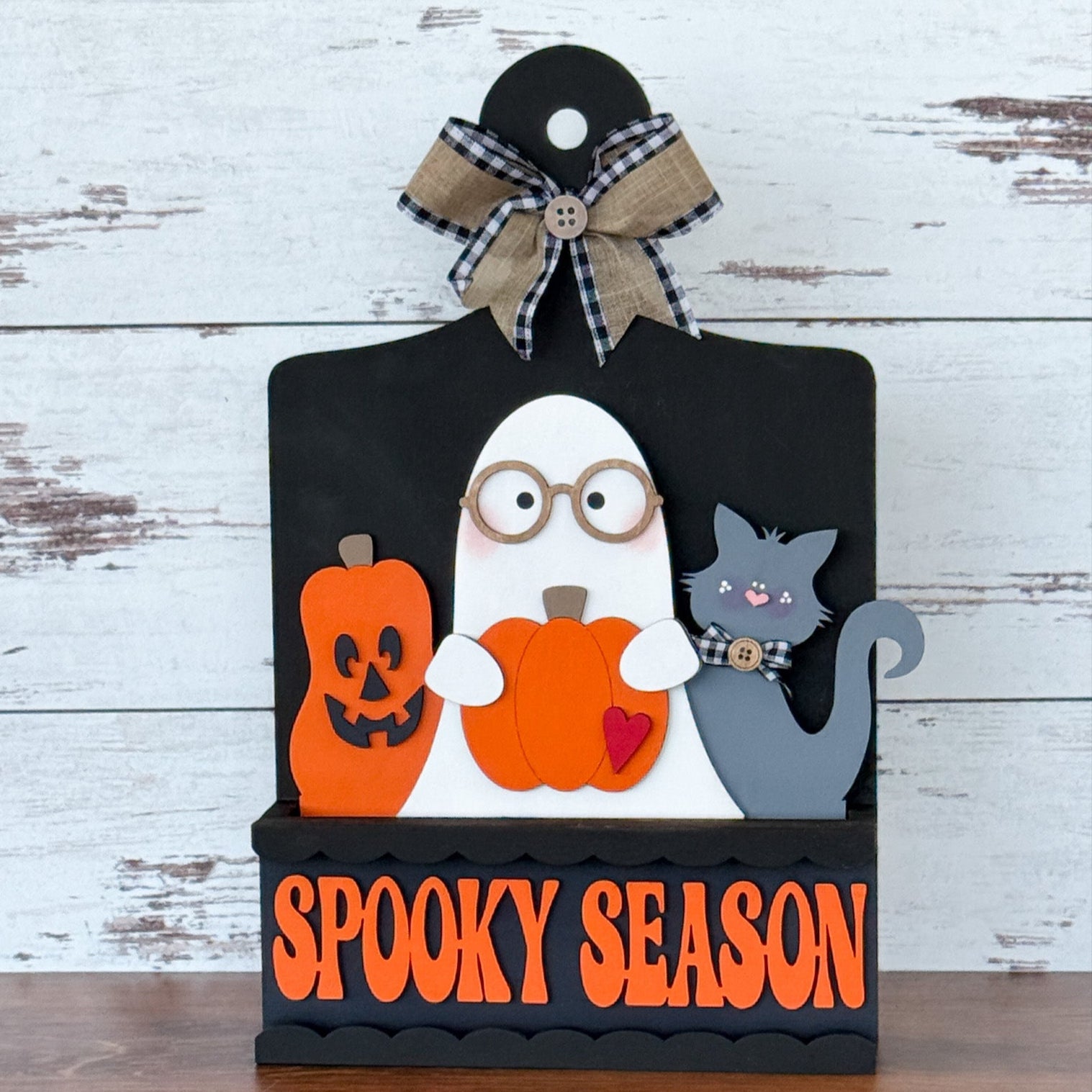 The Rustic Rhode’s DIY Spooky Season 2 Piece Insert features a ghost with glasses, pumpkin, black cat, and jack-o’-lantern above “Spooky Season” text—perfect for your interchangeable window frame.