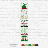 The Rustic Rhode's DIY Under Elf Watch Porch Leaner features the phrase "This house is under elf watch" with festive elf hat, belt, and shoes accents. Red, white, green, black, and gold paint colors are showcased on this charming holiday decor.