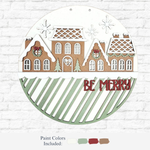The Rustic Rhode DIY Victorian Gingerbread Door Hanger features gingerbread-style houses with wreaths, snowflakes, and trees on a white and green striped background. Includes four paint colors—perfect for creating unique holiday décor.