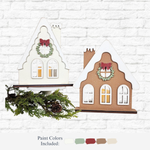 Set of two DIY Victorian Gingerbread House Votives by The Rustic Rhode—one white, one brown. Laser cut birch kit, no glue needed. Features snow-like roofs, wreaths, and windows. Perfect with votive candles, evergreens, and pinecones.