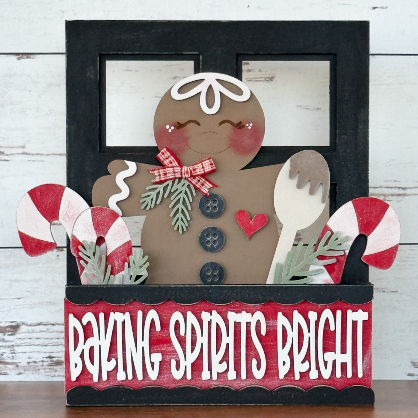 The Rustic Rhode DIY Gingerbread 2 Piece Insert features a smiling gingerbread figure with a bow, wooden spoon, candy canes, and greenery in a box that reads Baking Spirits Bright on a red and black background.