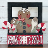 The Rustic Rhode DIY Gingerbread 2 Piece Insert features a smiling gingerbread figure with a bow, wooden spoon, candy canes, and greenery in a box that reads Baking Spirits Bright on a red and black background.