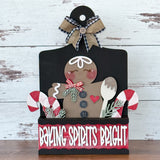 The Rustic Rhode DIY Gingerbread 2 Piece Insert features a smiling gingerbread figure with buttons, candy canes, greenery, and a wooden spoon on a black background topped with a bow and Baking Spirits Bright in white and red—perfect for seasonal décor.